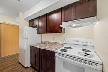 Forest Lake townhouse for rent - A kitchen with a white stove and white refrigerator.