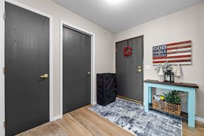 Forest Lake apartment for rent - A room with a black door, a grey door, and a black suitcase on the floor.