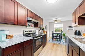 Forest Lake apartment for rent - A kitchen with dark wood cabinets and a granite counter top.
