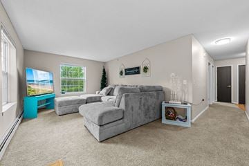 Forest Lake apartment for rent - A living room with a grey couch and a blue side table.