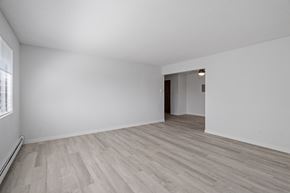 St Cloud apartment for rent - the living room and dining room of an apartment with white walls and wood flooring