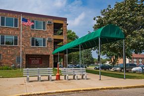 Marshall apartment for rent - a building with two benches and a green canopy in front of it