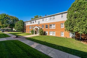 Owatonna apartment for rent - exterior view of a brick building with green grass and trees