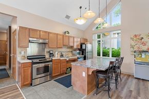 Stillwater townhouse for rent - a kitchen with wooden cabinets and stainless steel appliances and a marble counter top