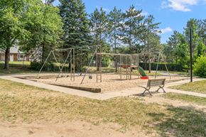 Stillwater townhouse for rent - a playground with a swing set and a bench in a park