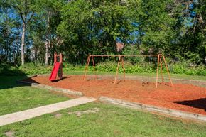 Owatonna apartment for rent - a swing set in a park with trees