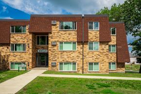 Coon Rapids apartment for rent - the front of a brick building with green windows
