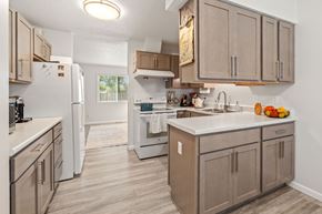 Burnsville townhouse for rent - A kitchen with a white refrigerator and brown cabinets.