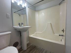 Owatonna apartment for rent - A white bathroom with a toilet, sink, and bathtub.