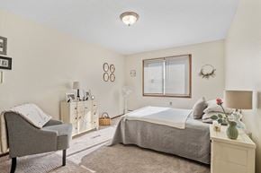 Forest Lake apartment for rent - a bedroom with a bed and a chair and a window