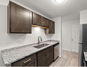 St Cloud apartment for rent - A kitchen with brown cabinets and granite countertops.