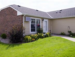 Stillwater apartment for rent - a front yard with yellow flowers and a house