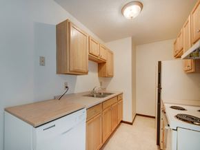 White Bear Lake apartment for rent - a kitchen with white appliances and wooden cabinets