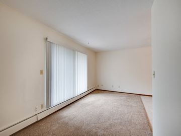 White Bear Lake apartment for rent - the living room and bedroom of an apartment with white walls and carpet