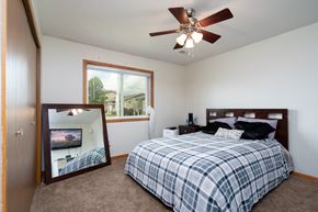 Forest Lake apartment for rent - a bedroom with a bed and a mirror and a ceiling fan