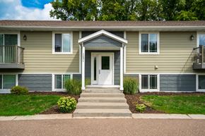 Forest Lake apartment for rent - A two-story residential building with a front porch and a white door.