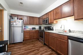 Forest Lake apartment for rent - A kitchen with wooden cabinets and a stainless steel refrigerator.