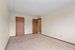 Mankato apartment for rent - a spacious living room with carpet and a door to a hallway