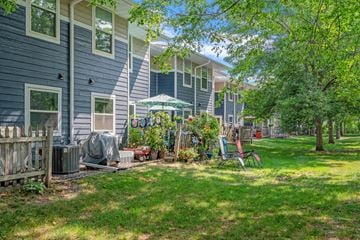 Stillwater apartment for rent - a group of blue houses with a lawn and trees in front of them