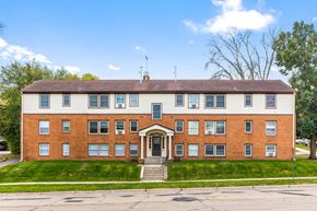 Faribault apartment for rent - A red brick building with a brown roof and a white door.