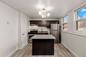 Faribault apartment for rent - A kitchen with a refrigerator, stove, and island.