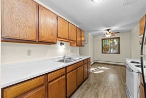 Stillwater apartment for rent - A kitchen with wooden cabinets and a white stove top oven.