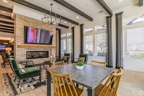 Boerne apartment for rent - A modern dining room with a stone fireplace and a large TV above it.
