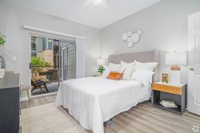San Antonio apartment for rent - A bedroom with a large bed and a sliding glass door.