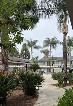 Tustin apartment for rent - A building with a pool in front of it.