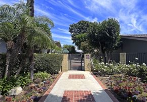 Garden Grove apartment for rent - A garden with a brick pathway leading to a gate.