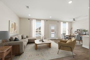 Findlay apartment for rent - A well-lit living room with a grey sofa, a wooden coffee table, and a yellow armchair.