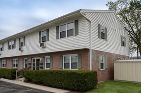 Defiance apartment for rent - A two-story building with a grey roof and green shutters.