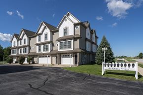 Perrysburg apartment for rent - A large, multi-story building with a white sign in front that reads "The Colonial Woods.".