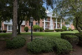 Toledo townhouse for rent - A large building with a white front porch and a black lamp post.