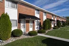 Waterville apartment for rent - A row of houses with a white and red brick facade.