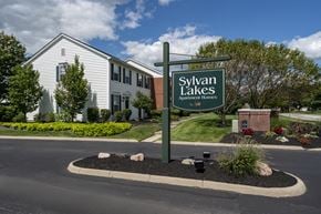 Sylvania apartment for rent - A sign for Sylvan Lakes Apartment Homes stands in front of a building.