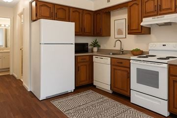 Toledo townhouse for rent - A white refrigerator stands in a kitchen with wooden cabinets and white appliances.