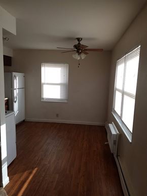 Bryan apartment for rent - A room with a ceiling fan and two windows.