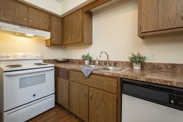 Toledo apartment for rent - A kitchen with a white stove and wooden cabinets.