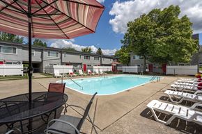 Toledo apartment for rent - A pool surrounded by chairs and umbrellas.