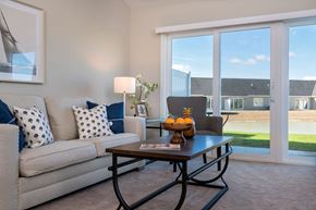 Findlay apartment for rent - A living room with a grey couch, a coffee table, and a large window.