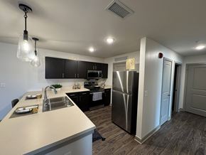 Bloomington apartment for rent - A modern kitchen with a stainless steel refrigerator and a dining table set for two.