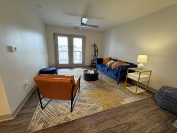 Bloomington apartment for rent - A living room with a blue couch and an orange chair.