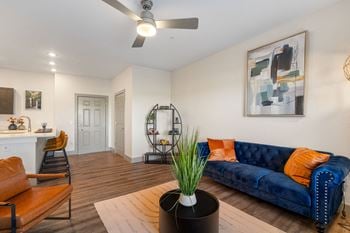 A living room with a blue couch and a ceiling fan