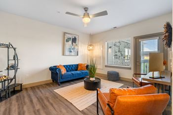 A living room with a blue couch and a ceiling fan