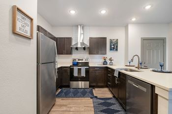 An open kitchen with stainless steel appliances and a refrigerator