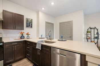 A kitchen with a large counter top and stainless steel appliances