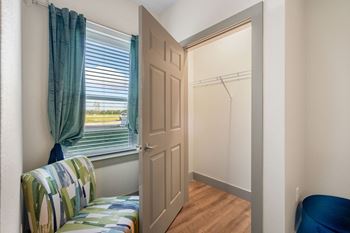A bedroom with a window and a closet with a door