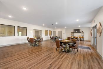 A large community room with a dining room table and chairs
