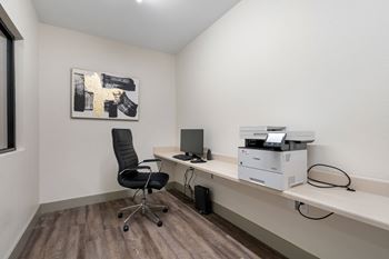 An office with a computer and a printer on a desk